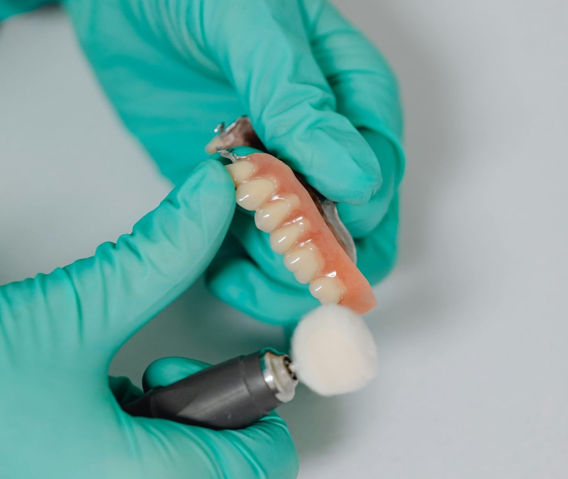 hands buffing a digital denture